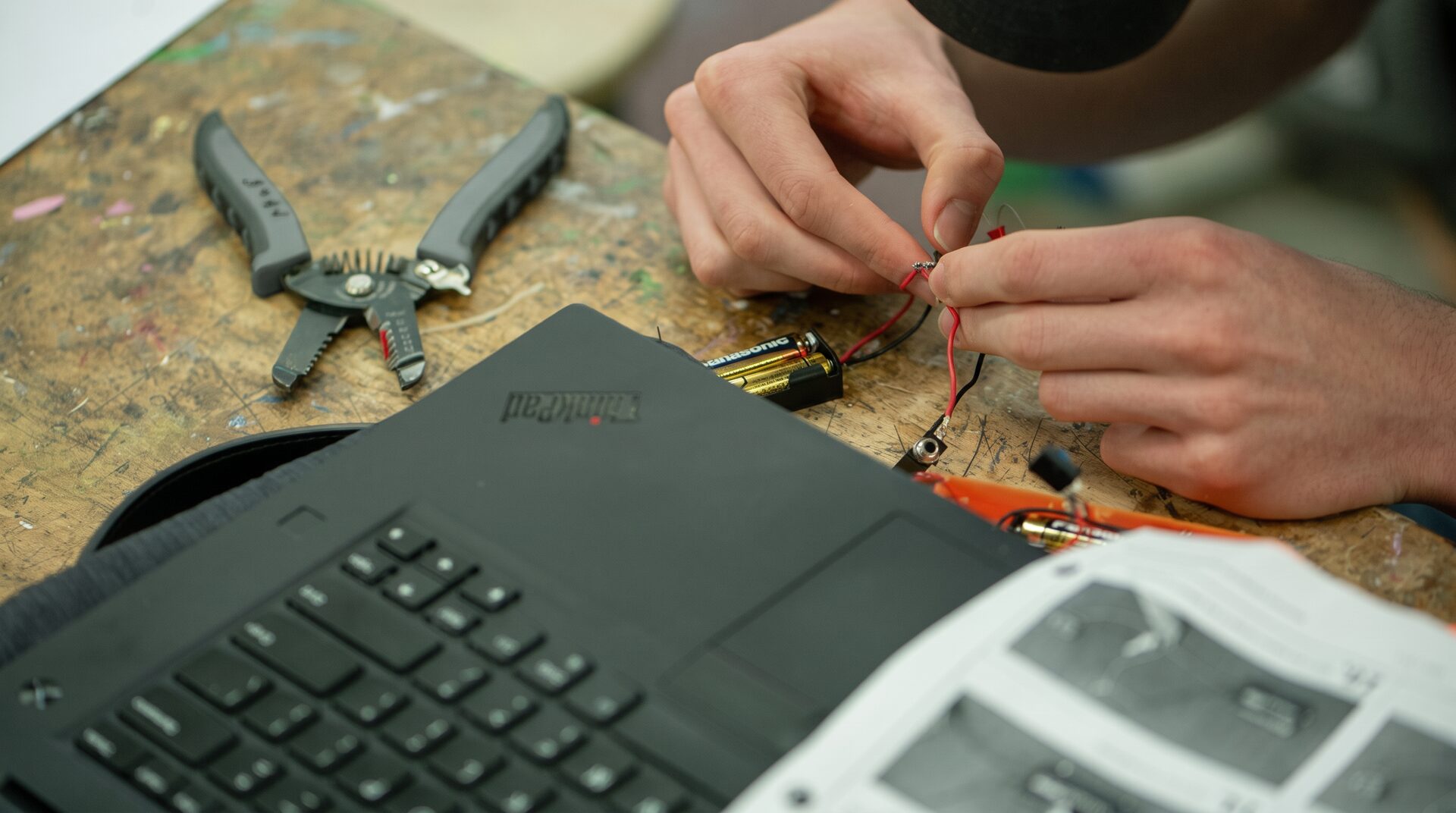 Hände bei der Reparatur eines Notebooks auf der Werkbank